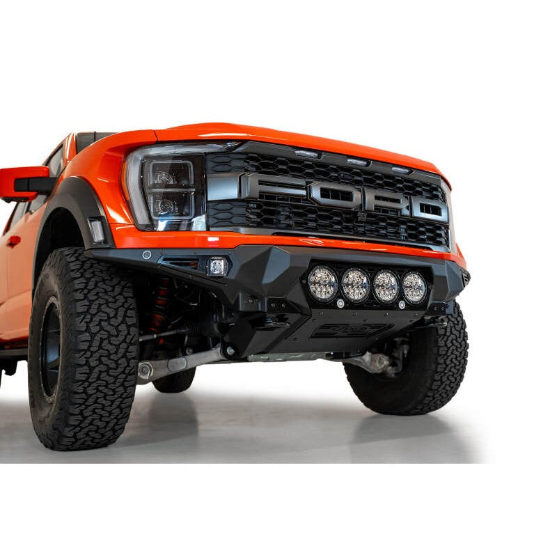 Hammer black Addictive Desert Designs Bomber front bumper with mounts for 4 Rigid 360 6-inch lights on a Ford F-150 Raptor.