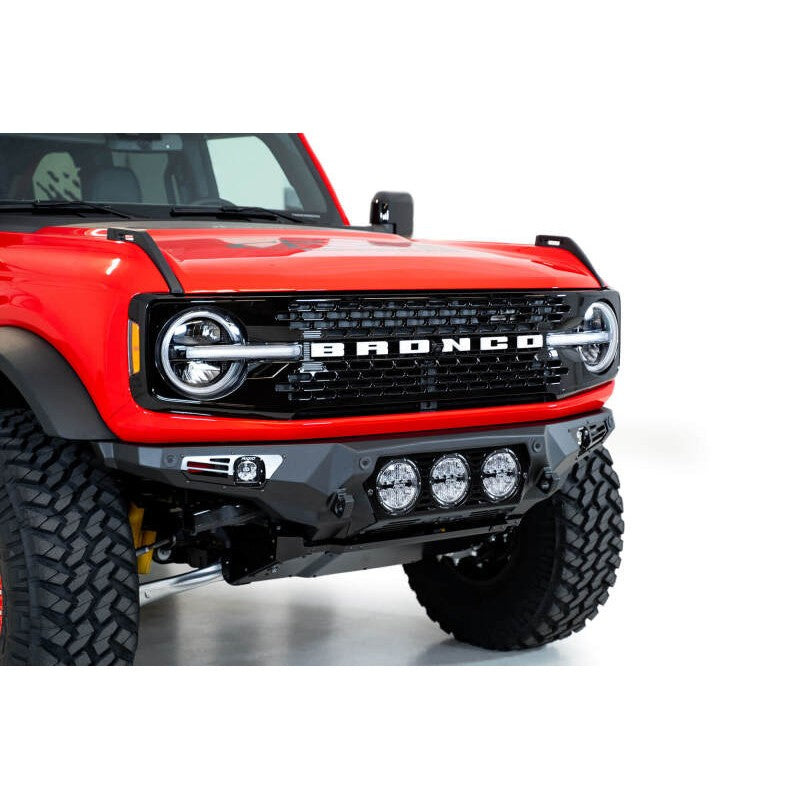 Hammer Black Addictive Desert Designs Bomber front bumper for 2021-2025 Ford Bronco with mounts for three 6-inch lights.