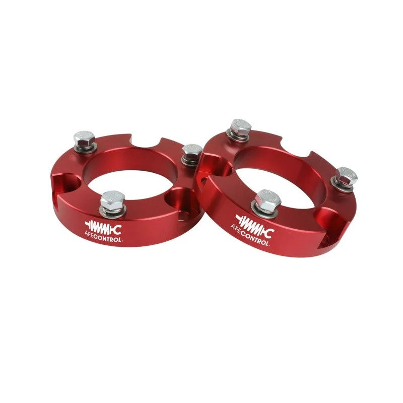 Red anodized aFe CONTROL 2.0-inch CNC machined billet aluminum leveling spacers for 2003-2023 Toyota trucks.