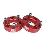 Pair of red anodized CNC machined aluminum leveling spacers with mounting hardware for 2006-2024 Ram 1500 trucks.