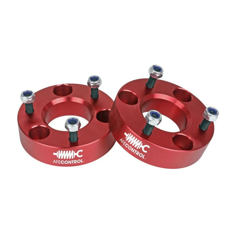 Pair of red anodized CNC machined aluminum leveling spacers with mounting hardware for 2006-2024 Ram 1500 trucks.