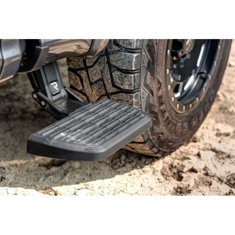 Black AMP Research BedStep2 retractable aluminum side step for Ford F-150 truck beds.