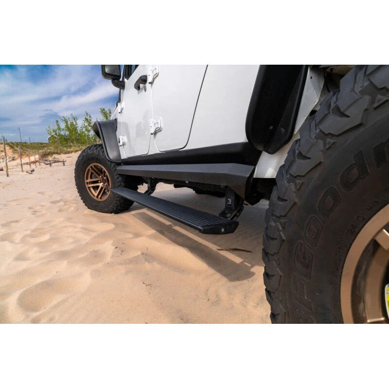 Black AMP Research PowerStep XL electric running board installed on a 4-door Jeep Wrangler JL