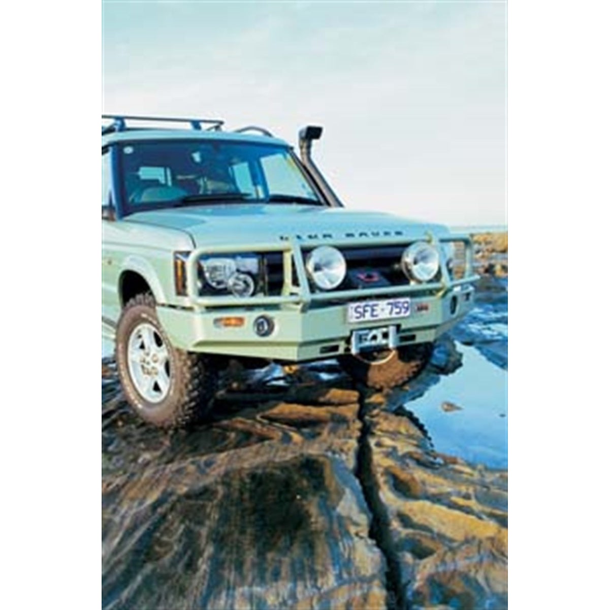 Black powder coated ARB Deluxe Winch Bar front bumper for 2003-2004 Land Rover Discovery II showing fog light ports.
