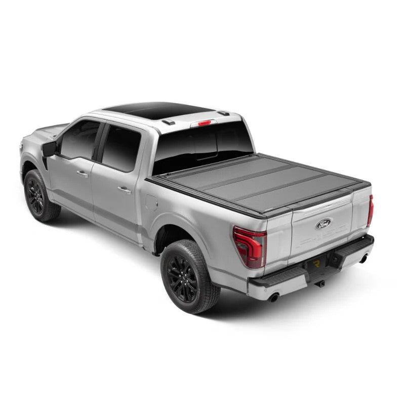 Matte black BAKFlip MX4 hard folding truck bed cover installed flush on a Ford F-150 with a 6.5-foot bed.