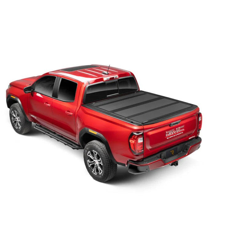 BAKFlip MX4 matte black hard folding truck bed cover installed flush on a mid-size pickup truck 5-foot bed.