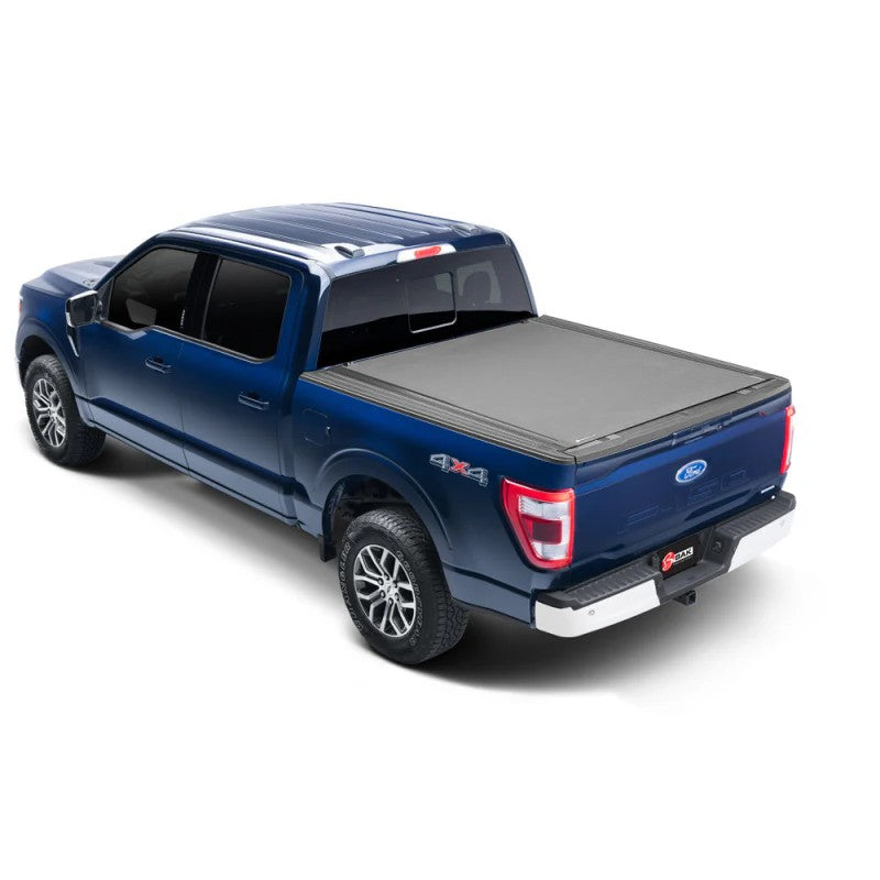 BAK Revolver X4s matte black hard roll-up tonneau cover installed on a 2021-2025 Ford F-150 pickup truck bed