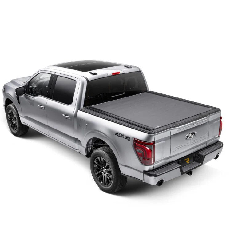 BAK Revolver X4ts matte black hard roll-up tonneau cover with integrated T-slot rails on a Ford F-150 5.7ft bed.
