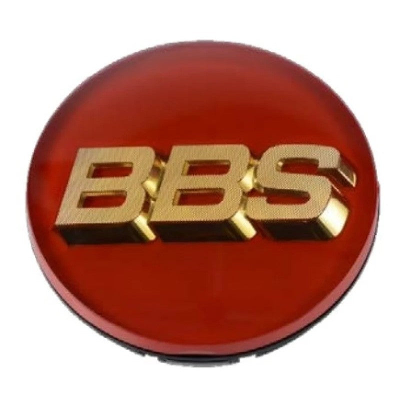 BBS wheel center cap featuring a red background, gold logo, and three-tab mounting clips on the reverse side.