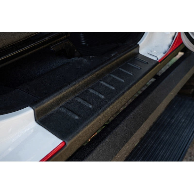 Bushwacker Trail Armor matte black TPO rocker panel protection installed on the lower body of a Jeep Gladiator.