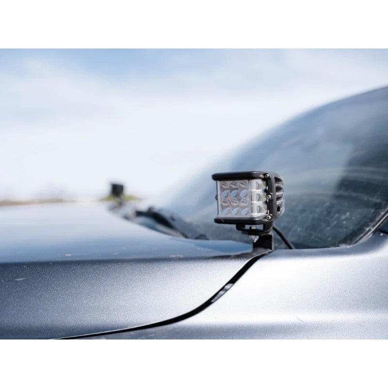 Cali Raised low profile ditch light brackets and small LED pods with blue backlight installed on a Toyota Tacoma.