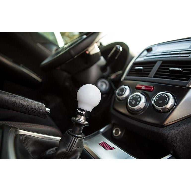 Cobb white 6-speed shift knob with stealth black collar and engraved shift pattern.