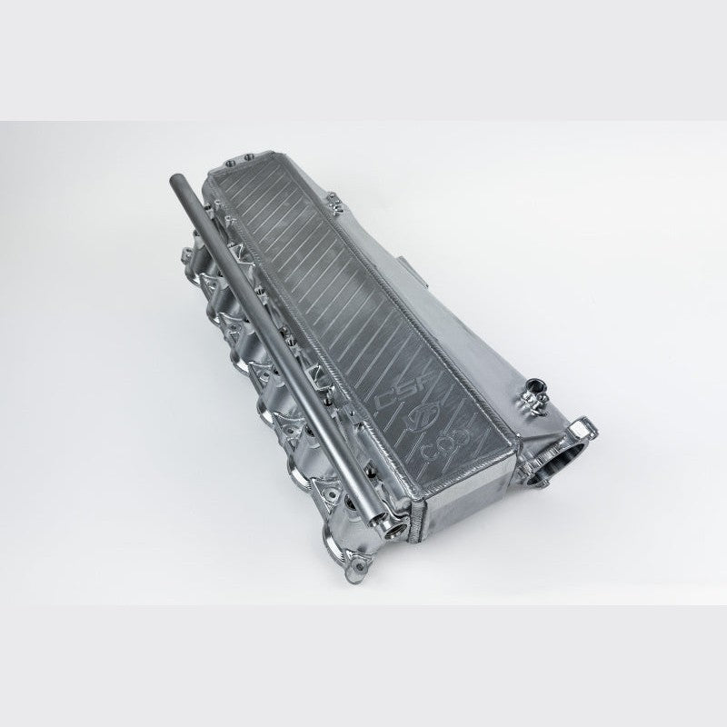 CSF raw machined billet aluminum charge-air-cooler manifold for Gen 1 BMW B58 engines showcasing ports and cooling core.