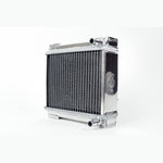 Polished aluminum CSF auxiliary radiator with B-Tube core and black mesh rock guard.