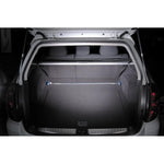 Cusco Type OS rear strut tower bar featuring a polished oval aluminum shaft and blue powder-coated mounting brackets.