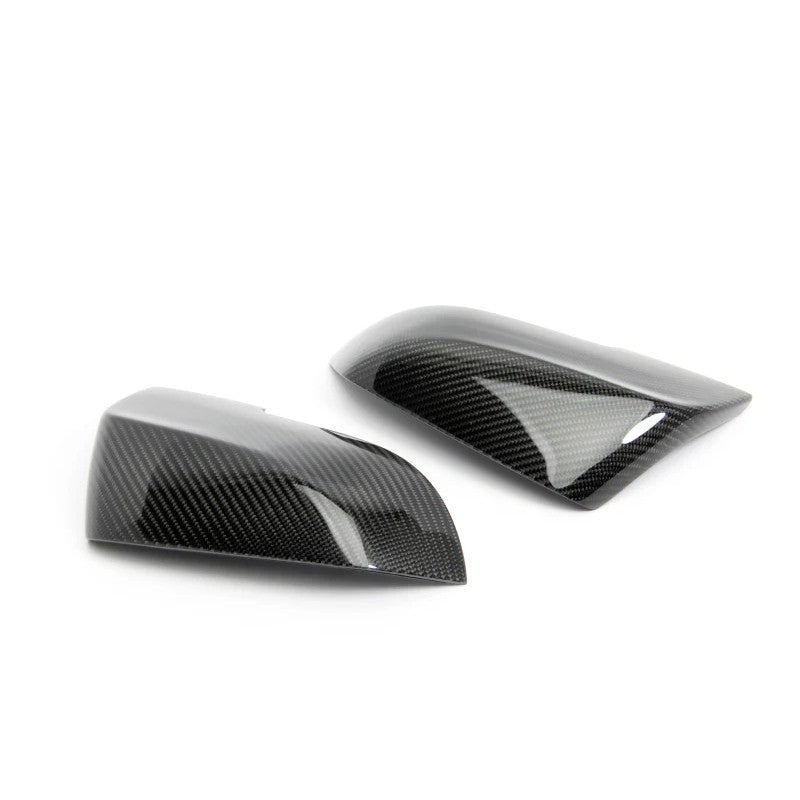 Set of two Dinan clear-coated carbon fiber mirror covers with injection-molded mounting clips.