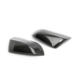 Set of two Dinan clear-coated carbon fiber mirror covers with injection-molded mounting clips.