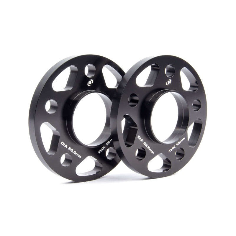 A pair of black anodized Dinan 15mm wheel spacers featuring a 5x112 bolt pattern and 66.5mm center bore.
