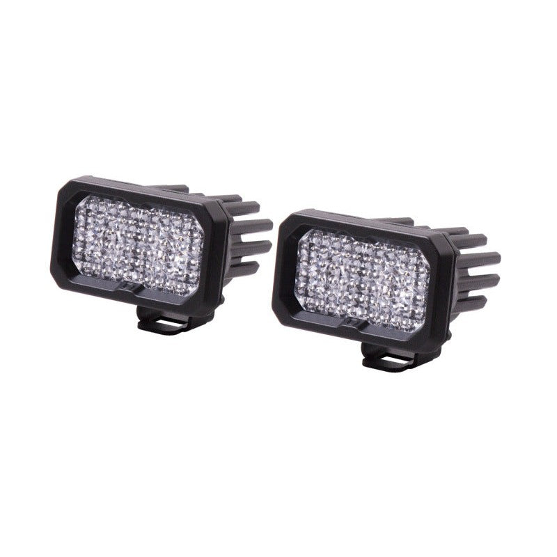 Pair of black Diode Dynamics Stage Series 2in white flood LED pods with TIR optics and integrated heatsinks.