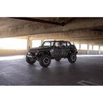 DV8 Offroad FS-15 Series black powder-coated stubby front bumper with bull bar and winch mount for Jeep Wrangler.