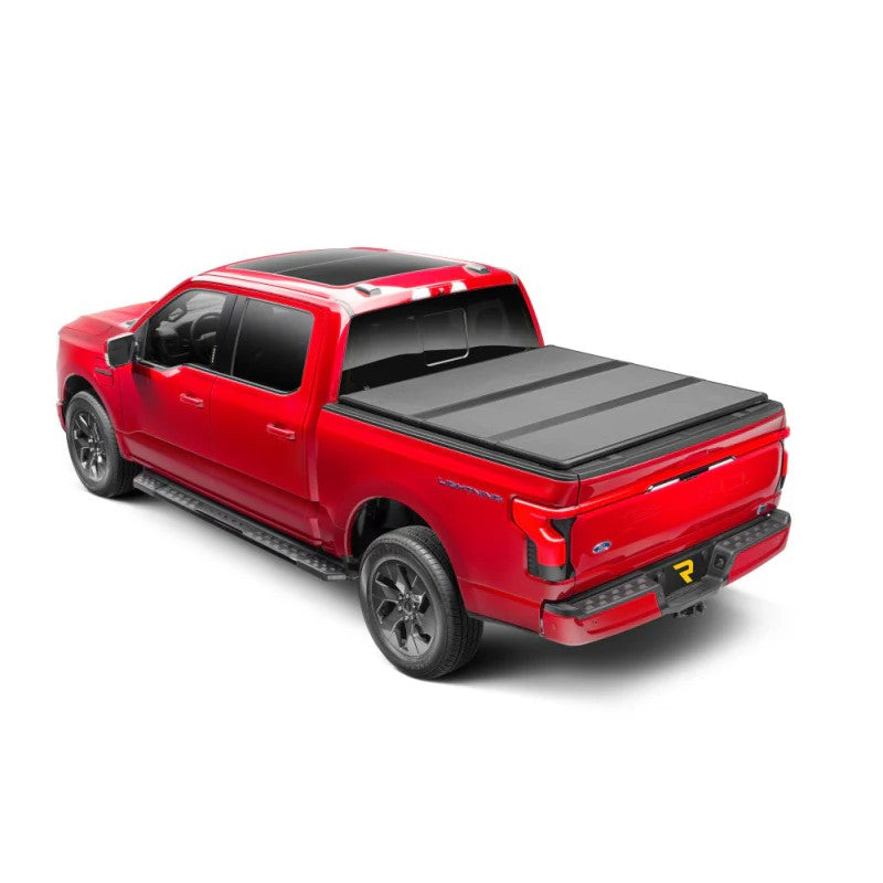Extang Solid Fold ALX hard tri-fold tonneau cover in matte black on a Ford F-150 truck bed.