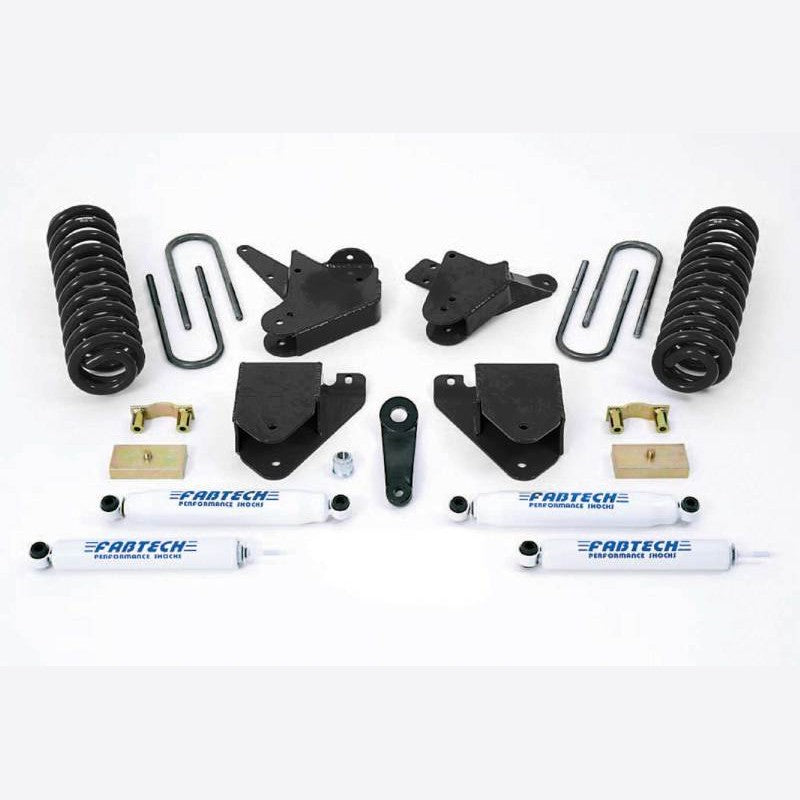 Fabtech K2100 6-inch lift kit components including white performance shocks, black coil springs, and heavy duty brackets