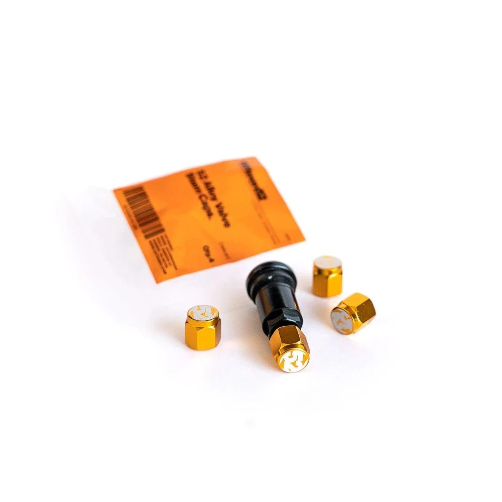 Set of four gold Fifteen52 valve stem caps for automotive tire Schrader valves.