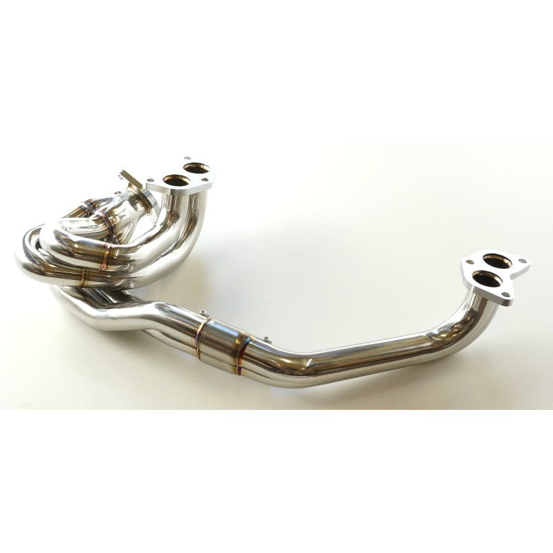 HKS stainless steel exhaust manifold for STI featuring polished mandrel-bent tubing and precision-welded flanges.