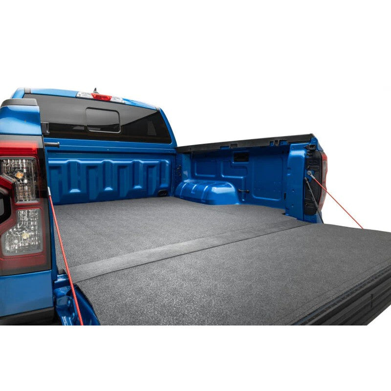 Husky Liners Guardian Impact heavy-duty black bed and tailgate mat installed in a Toyota Tacoma 5ft truck bed
