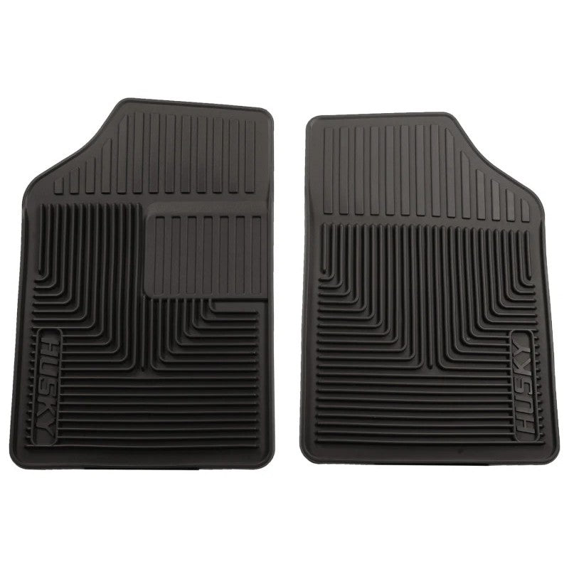 A pair of black Husky Liners 51051 Heavy Duty front floor mats with center liquid channels and StayPut Cleats.