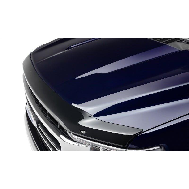 Dark smoke acrylic Husky Liners Aeroskin hood protector mounted on the front edge of a Ford Super Duty hood.