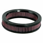 Round K&N high-flow replacement air filter with red pleated oiled cotton media and black rubber seals.