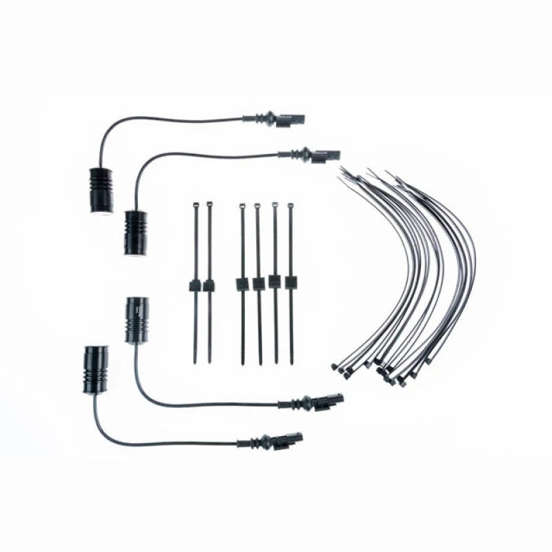 KW Electronic Damping Cancellation Kit modules with factory-style connectors for Chevrolet Camaro and Ford Mustang.