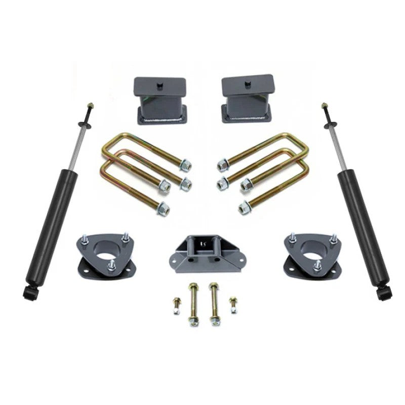 MaxTrac 4-inch rear lift kit for Nissan Titan featuring blocks, U-bolts, carrier bearing drop bracket, and twin-tube shocks.