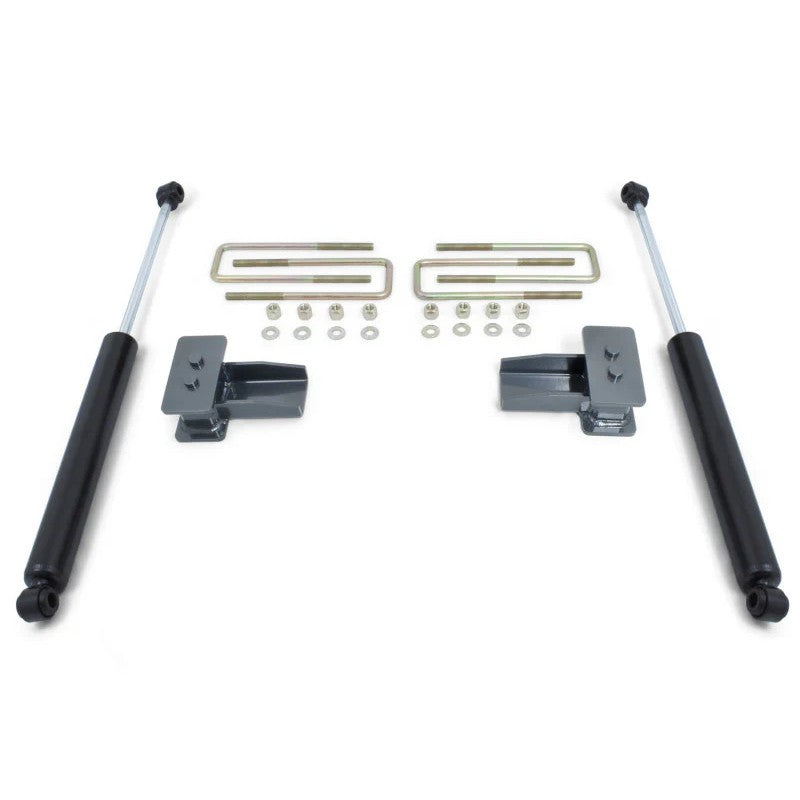 MaxTrac 2-inch rear lift kit components including black lift blocks, U-bolts, hardware, and two MaxTrac shocks.