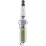 NGK R7448A-9 Racing spark plug showing the electrode, ceramic insulator, and trivalent metal plated threads.