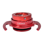 Red anodized NRG Gen 4.0 steering wheel quick release kit with flared pull handles and ball-lock mechanism.