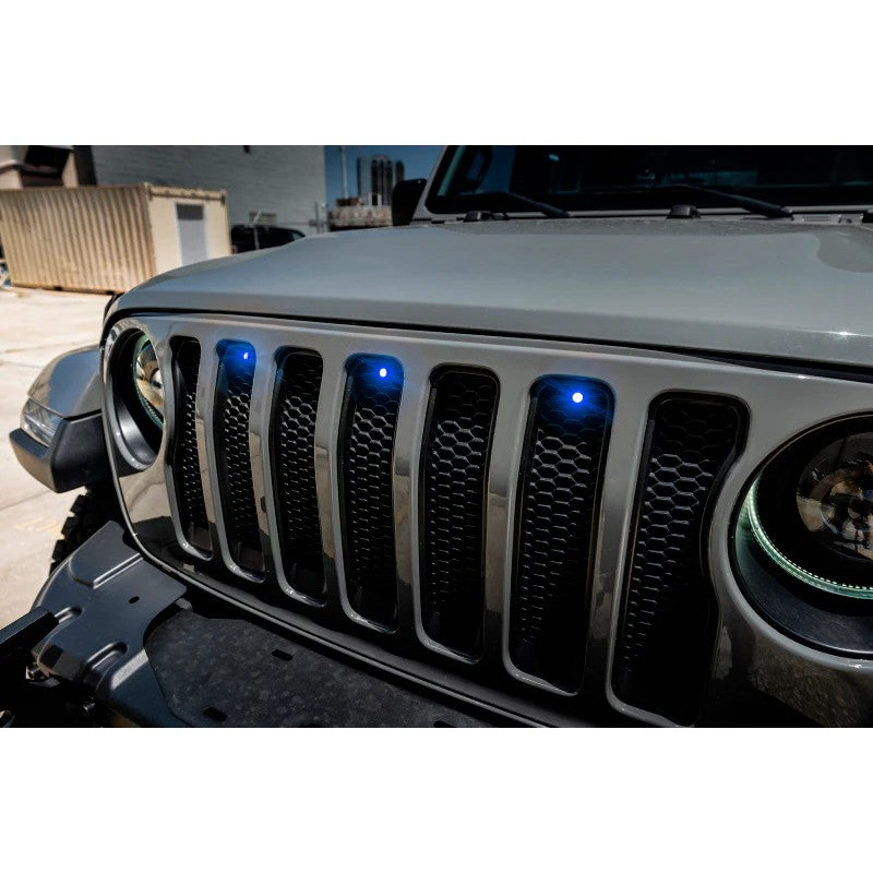 Three 3-watt blue LED marker lights mounted in the front grille openings of a 2018-2023 Jeep Wrangler JL.