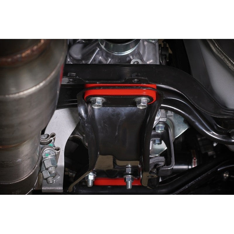 Four black PERRIN polyurethane transmission crossmember bushings with metal sleeves for Subaru WRX, STI, and Forester.