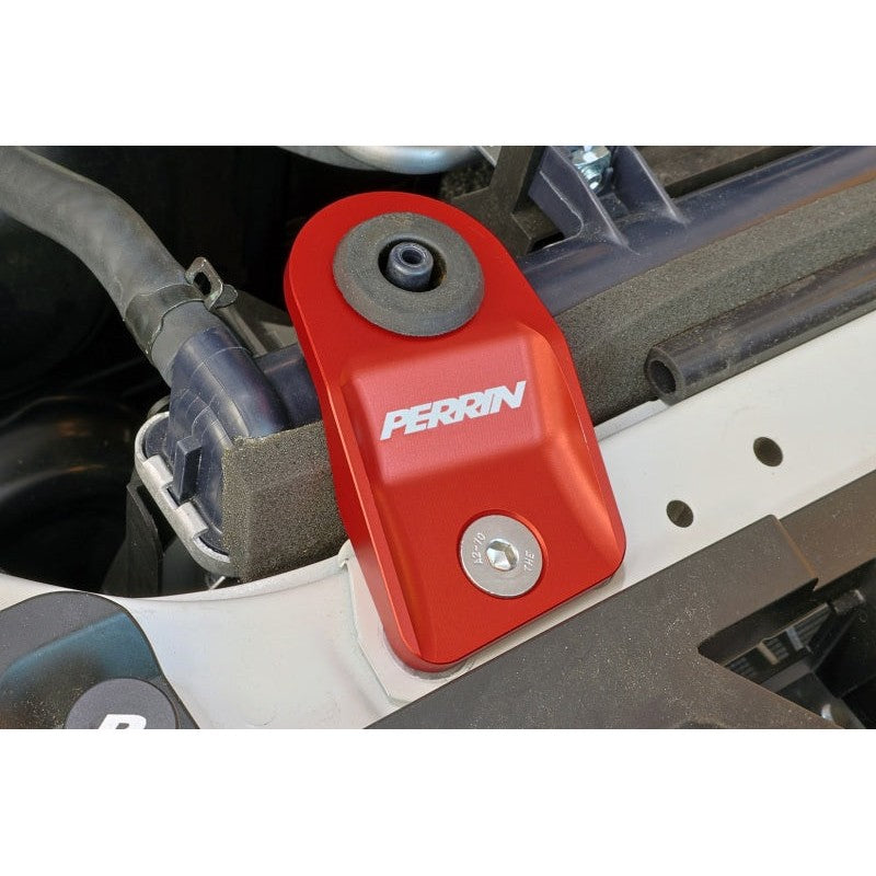 Set of two PERRIN red powder-coated aluminum upper radiator brackets for Subaru engine bays.