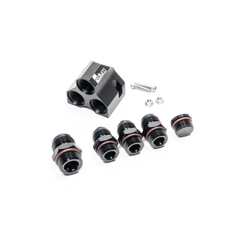 Black anodized Radium Engineering fuel distribution block with one -12AN and three -10AN fittings installed.