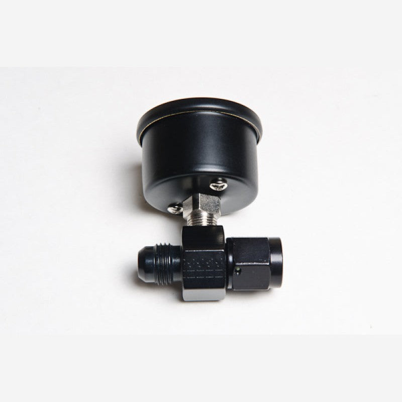 Radium Engineering mechanical fuel pressure gauge attached to a black anodized -6AN inline adapter fitting.