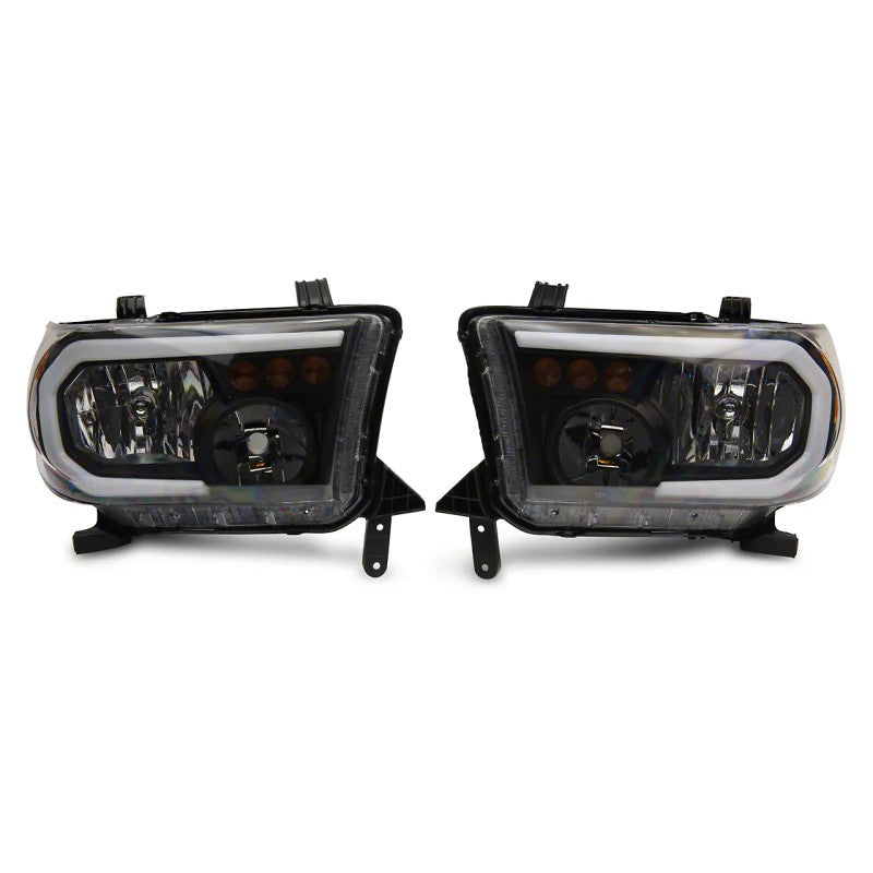 Raxiom Axial Series headlights for 2007-2013 Toyota Tundra featuring black housings, clear lenses, and LED DRL bars.