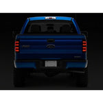 Raxiom Axial Series LED tail lights with black housings and smoked lenses for 2009-2014 Ford F-150 Styleside trucks.