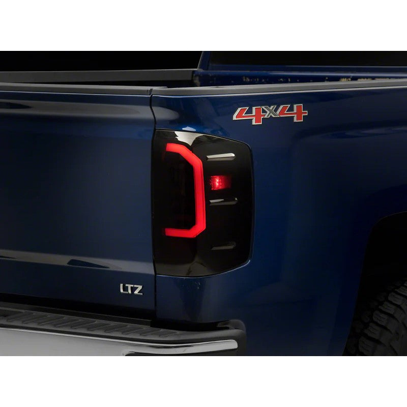 Raxiom Axial Series LED tail lights with black housing and smoked lens for Chevrolet Silverado.