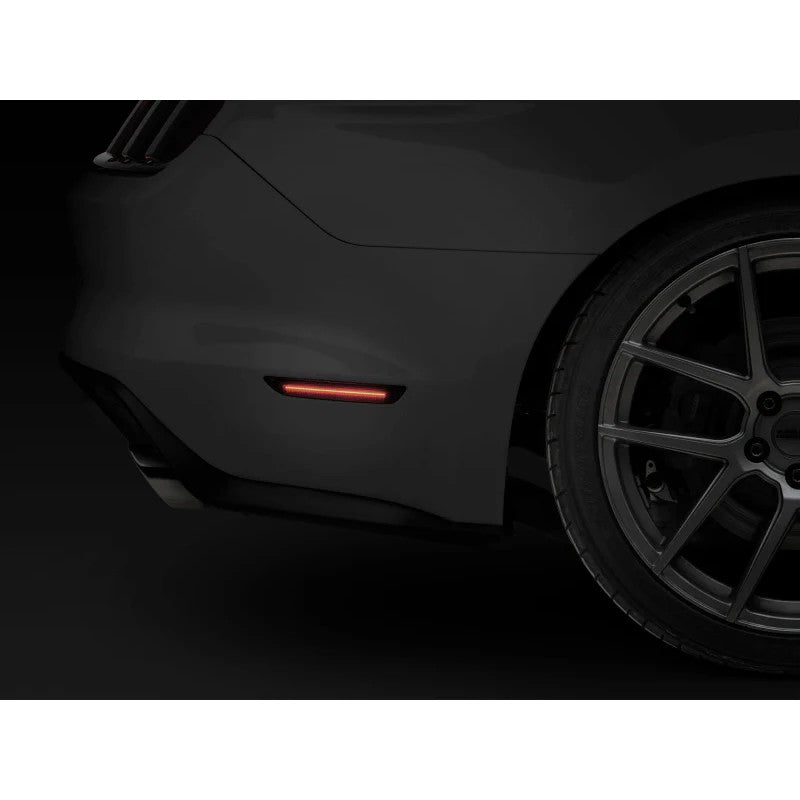 A pair of Raxiom Axial Series smoked rear LED side marker housings with red SMD focal strips for 2015-2023 Ford Mustang.