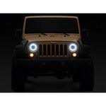 Raxiom HiOutput LED headlights with black housings, clear lenses, and circular Angel Eye DRLs for Jeep Wrangler JL.