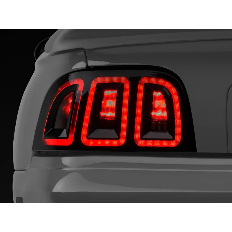 Raxiom Icon LED tail light assembly for 1996-1998 Ford Mustang featuring black housings and smoked lenses.