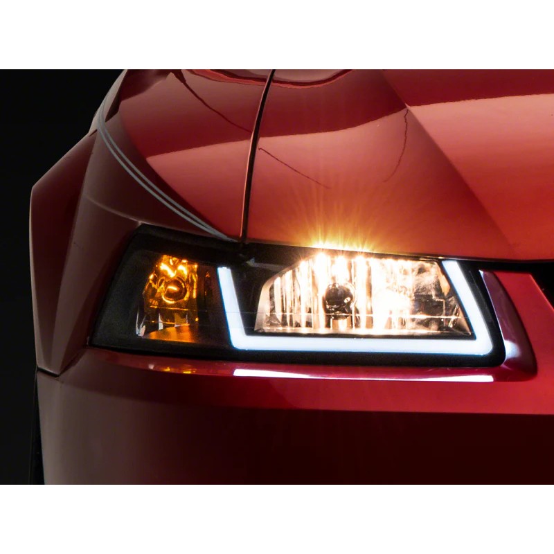 Raxiom Axial Series black housing headlights with integrated white LED DRL bar and clear lens for 1999-2004 Ford Mustang.