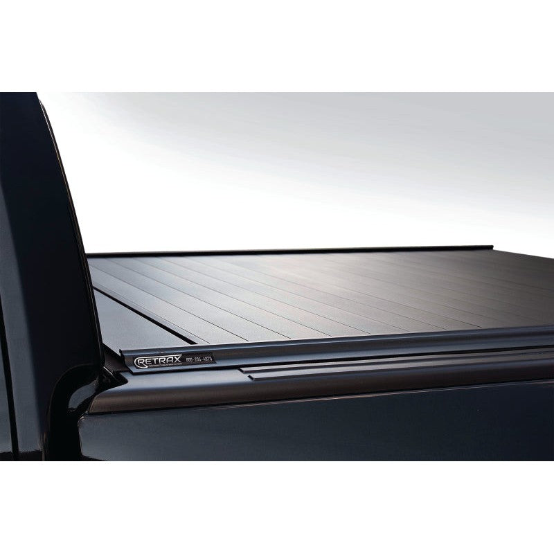 Matte black RetraxPRO MX retractable aluminum truck bed cover with key-lockable handle on a Dodge Ram pickup.